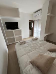 a large white bed in a room with a tv at DERC Temporarios in Río Cuarto