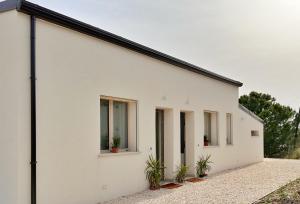 a white house with windows and plants at Villa Isma Superior Rooms in Realmonte