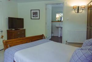 um quarto com uma cama e uma televisão de ecrã plano em White Lion em Hebden Bridge
