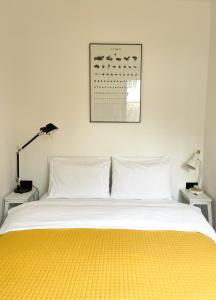 a bedroom with a bed with a yellow blanket on it at The Lodge in Kent
