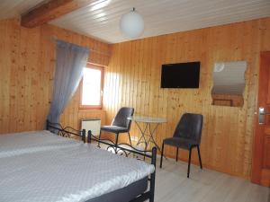 1 dormitorio con 1 cama, 2 sillas y mesa en Chambre d'hôte du Moulin en Savièse