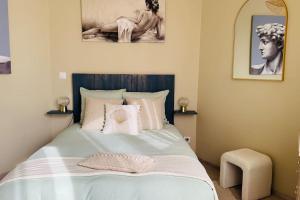 a bedroom with a bed with two pictures on the wall at L'Escapade marine appartement avec jacuzzi privé in Cayeux-sur-Mer