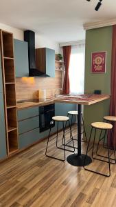 a kitchen with a table and stools in a room at Pristina City Apartment in Pristina