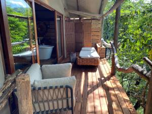 eine abgeschirmte Veranda mit einem Sofa und einem Tisch in der Unterkunft Summerfields Rose Retreat and Spa in Hazyview