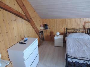 a bedroom with a bed and a dresser in a room at Chambre d'hôte du Moulin in Savièse