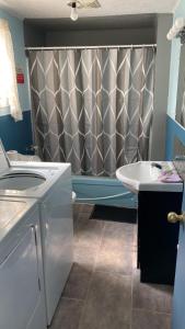 ein Bad mit einem Duschvorhang und einem Waschbecken in der Unterkunft Private Room 5 with Free WIFI and Parking in Edmundston