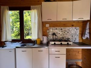 a kitchen with white cabinets and a sink at Domek wakacyjny nr 2 in Giżycko