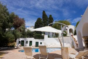 un patio con sillas y una sombrilla junto a la piscina en Si Brahim studio piscine, Sidi Bou Saïd en Sidi Bou Saïd