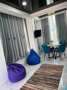 sala de estar con mesa y sillas azules en Kutaisi Apartment en Kutaisi