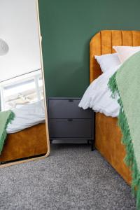 um quarto com uma cama e um espelho em Cozy 2-Bedroom - Cyncoed Area em Cardiff