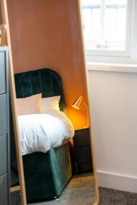 - un miroir réfléchissant le lit dans la chambre dans l'établissement Cozy 2-Bedroom - Cyncoed Area, à Cardiff