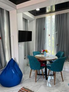 a dining room with a table and blue chairs at Kutaisi Apartment in Kutaisi