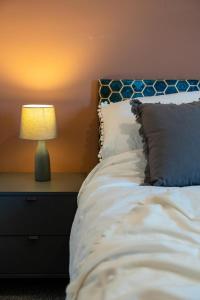 um quarto com uma cama com um candeeiro numa mesa de cabeceira em Cozy 2-Bedroom - Cyncoed Area em Cardiff