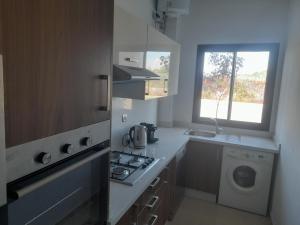 a kitchen with a stove top oven next to a window at Vacances Soleil Piscine & Plage Bouznika in Bouznika