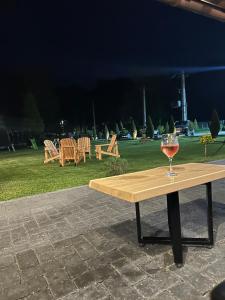 a wooden table with a glass of wine on it at Floare de Colț-Bran in Bran