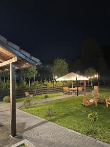 un parc avec des bancs et des parasols la nuit dans l'établissement Floare de Colț-Bran, à Bran