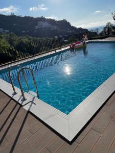 una gran piscina en una terraza de madera en Orange Villa Kvariati en Kvariati