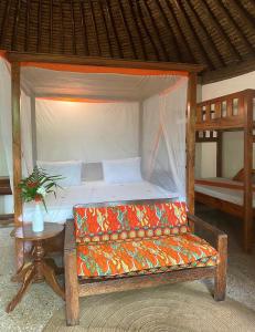 uma cama num quarto com um sofá e uma mesa em Lala Land Lodge em Kizimkazi