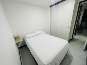 a bedroom with a white bed in a room at ¡Vista Increíble Apartamento Tamarindo! in Santa Fe de Antioquia