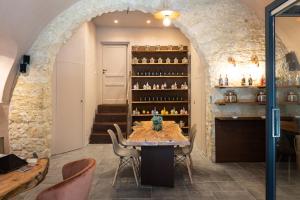 a dining room with a table and a shelf of bottles at La Martina Home in Valguarnera Caropepe