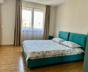 a bedroom with a blue bed with a window at Fenix 2 Bedroom Apartment Varna Center in Varna City