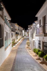 an empty street at night with white buildings at I AM La Posada Hotel and Apartment in Benalmádena
