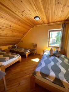 1 dormitorio con 2 camas en una habitación con techos de madera en Kārkli, en Kandava