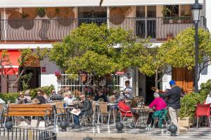 a group of people sitting at tables outside a restaurant at I AM La Posada Hotel and Apartment in Benalmádena