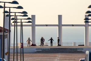 a group of people standing on a boardwalk near the beach at I AM Benalmádena in Benalmádena