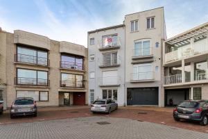 two cars parked in a parking lot in front of a building at Markt 28 Glvls in Wenduine