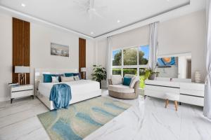 a white bedroom with a bed and a chair at The White House of Miami Perfect for Families Ω Friendly Close to Miami Beaches and the Keys West in Princeton +135 photos