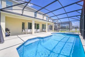 an indoor swimming pool with a glass roof at Stunning 9BR Home - Family Resort with Private Pool, Hot Tub, Games room and BBQ! in Kissimmee