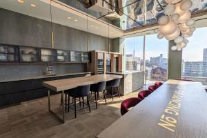 una cocina con mesas y sillas y una gran ventana en Charles Hope Manchester Centre, en Mánchester
