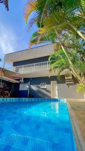 uma piscina em frente a um edifício com uma palmeira em POUSADA BRISA MAR em Ubatuba