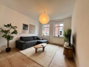 uma sala de estar com um sofá e uma mesa em FLATLIGHT - Stylish apartment - Kitchen - Parking - Netflix em Hildesheim