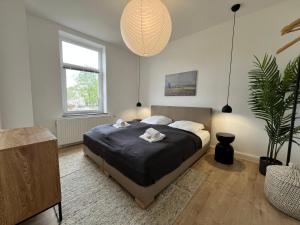 um quarto com uma cama e um vaso de plantas em FLATLIGHT - Stylish apartment - Kitchen - Parking - Netflix em Hildesheim