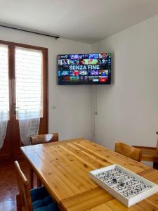 uma mesa de jantar com uma televisão na parede em TALAhome27 em Alghero