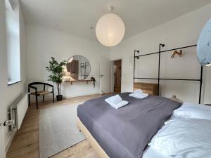a bedroom with a large bed with two towels on it at FLATLIGHT - Stylish apartment - Kitchen - Parking - Netflix in Hildesheim