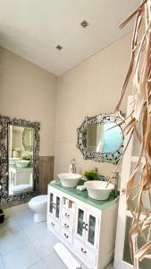 Baño con 2 lavabos y espejo en Frangipani Villa Seminyak, en Seminyak