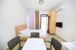 una stanza con due letti, un tavolo e delle sedie di Vila S&S a Vlorë