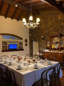 ein Esszimmer mit einem langen Tisch mit Stühlen und einem Kronleuchter in der Unterkunft Alto Chacras Cottage in Chacras de Coria