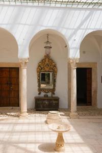 um quarto com uma mesa e um espelho na parede em Suite Noor B&B Pool SidiBouSaid em Sidi Bou Saïd