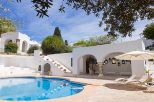uma piscina em frente a uma casa branca com cadeiras e um guarda-sol em Suite Noor B&B Pool SidiBouSaid em Sidi Bou Saïd