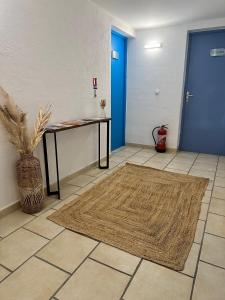 un pasillo con una mesa y una puerta azul en Résidence La Palma en Saintes-Maries-de-la-Mer