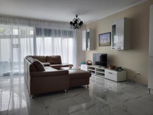 uma sala de estar com um sofá e uma televisão em Villa Vienna KN em Viena