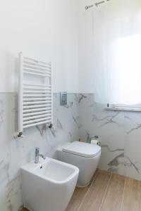 une salle de bains blanche avec toilettes et lavabo dans l'établissement MONDELLO COTTAGE, à Mondello