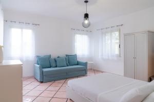 sala de estar con sofá azul y cama en MONDELLO COTTAGE en Mondello