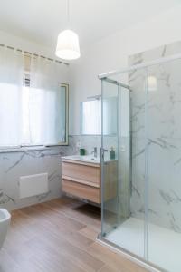 a bathroom with a glass shower and a sink at MONDELLO COTTAGE in Mondello