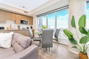 a living room and kitchen with a couch and a table at Brand New 1BR Condo - Balcony Amazing Views in Kitchener