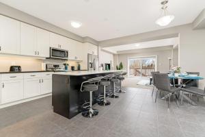 a kitchen with white cabinets and a black counter top at Serene 3BR Home - Sun Deck - Near Victoria Park in Kitchener